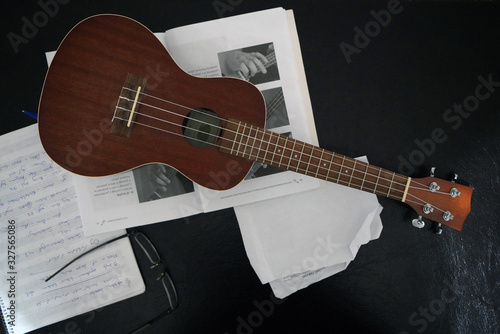 Musical note and ukulele on a black background