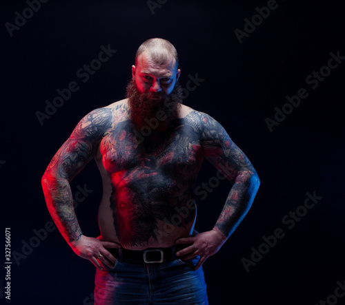 Cuadro en lienzo Tattooed brutal bearded man with a naked torso