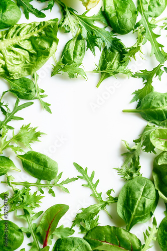 Colourful salad flat design on white background with copy space. Romaine, arugula, spinach and mizuna leaves flatlay. Vegan meal ingredients