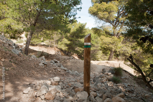 wooden pole with color indicator, for mountain routes, at the foot of the road
