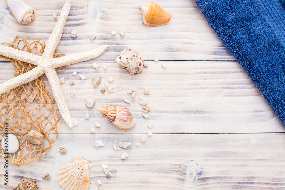 Starfish with sea shells on white wooden background.