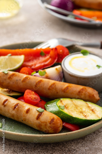 Grilled sausages with vegetables and sauce. Summer concept.