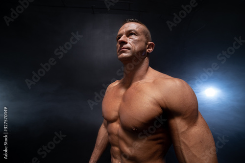 Muscular man isolated on the black background. Strong male naked torso abs