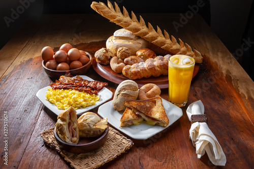 café da manhã com sanduiches, ovos, bacon e suco de laranja photo