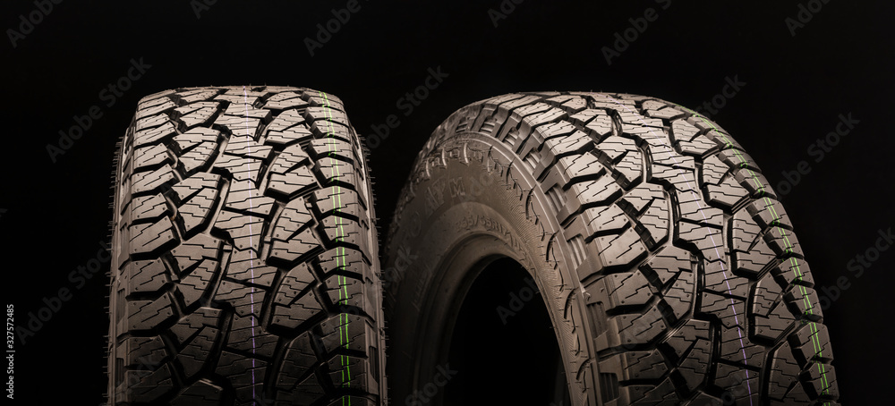 two off-road wheels with a powerful tread, mud pattern with slats, cuts and checkers on a black background. beautiful wheels for men's entertainment two off-road wheels with a powerful tread, mud pattern with slats, cuts and checkers on a black background. beautiful wheels for men's entertainment