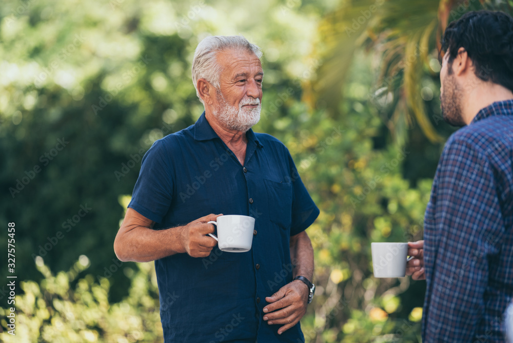 Old father and son, Morning coffee in a garden Old father and son, Morning coffee in a garden
