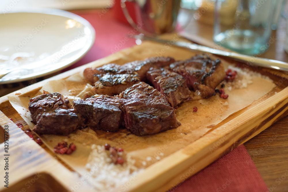 beef steak on a wooden board in a restaurant.