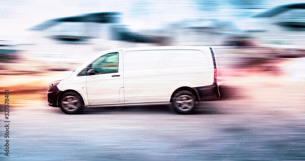 White delivery van speeding on road with blurred background.
