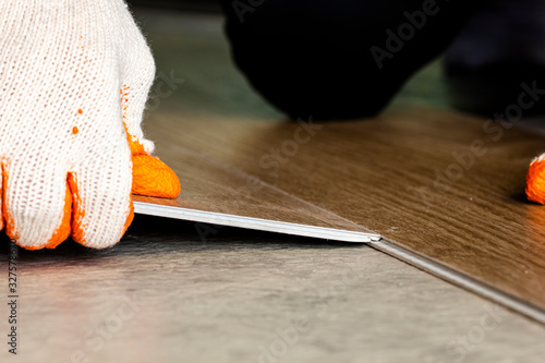 contractor installing vinyl floor tile with click lock type on floor