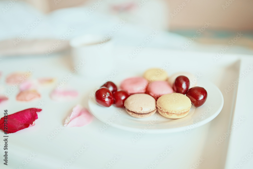 Side view of cup of coffee with tasty colorful macarons or macaroons on white tray. Romantic breakfast concept Side view of cup of coffee with tasty colorful macarons or macaroons on white tray. Romantic breakfast concept