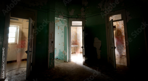 Unrecognised person walking alone through the  doors of an abandoned room.