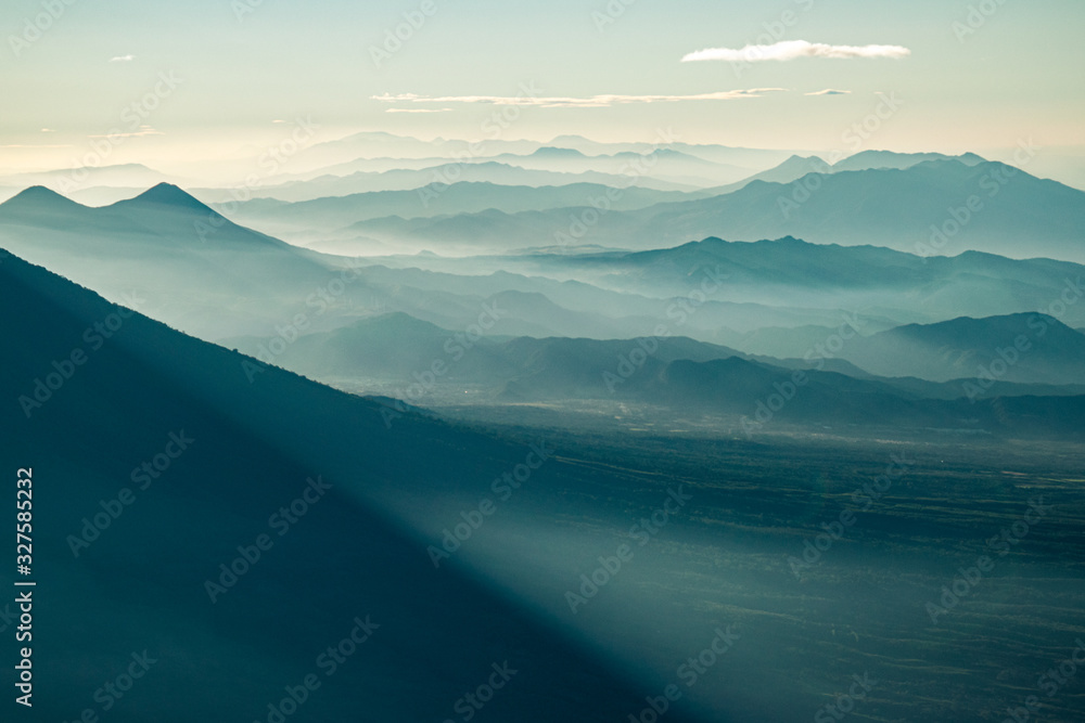 Φωτογραφία Abstract close-up landscape of Guatemalan volcanic Highlands with mountain silhouettes covered in morning mist seen from Acatenango volcano