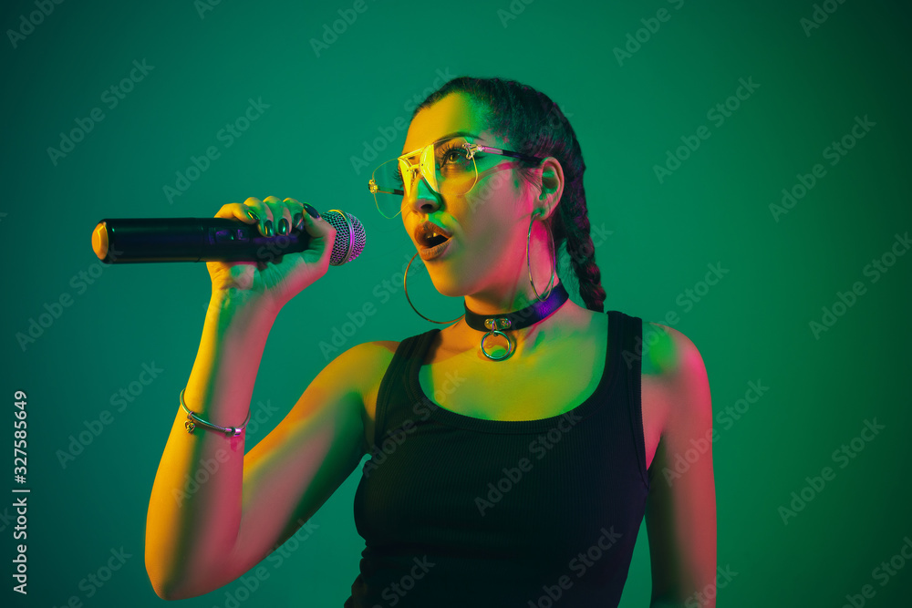 Caucasian female singer portrait isolated on green studio background in ...