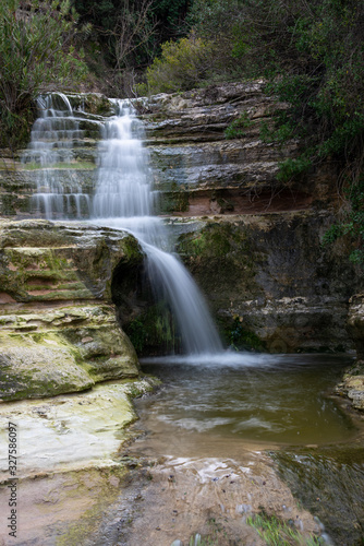 Beautiful waterfall splashing in the canyon creating a small lake