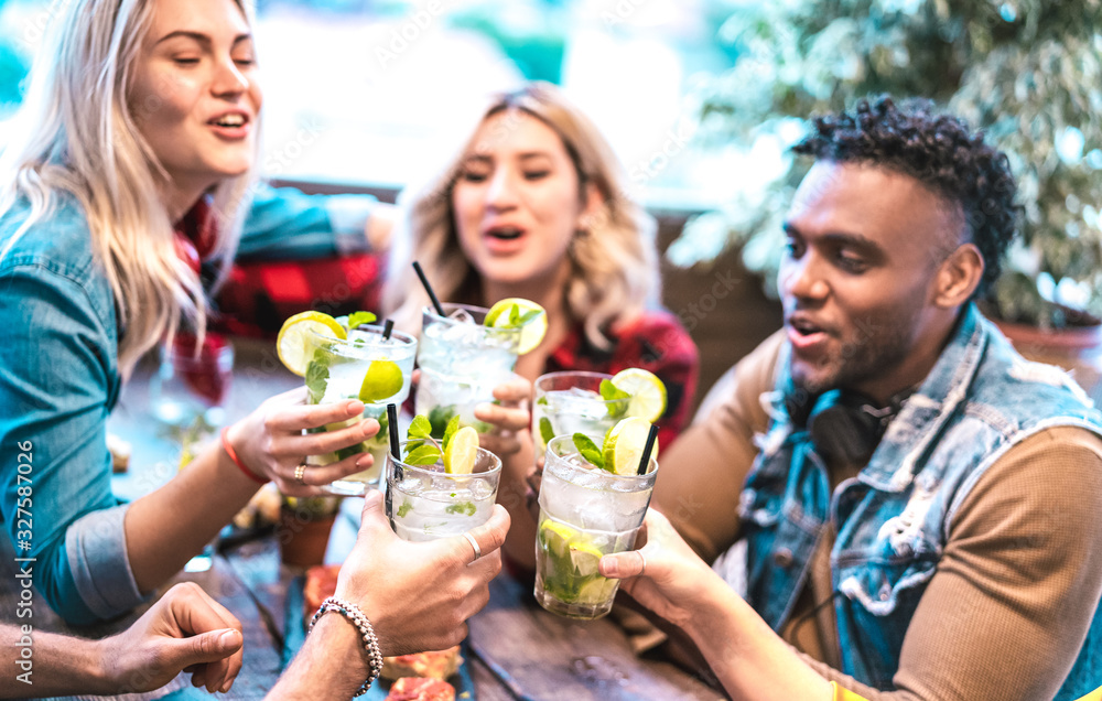 © Mirko Vitali - Best friends toasting mojito drinks at fashion cocktail bar restaurant - Party time concept with young people having drunk fun drinking on happy hour at pub - Focus on lower left glass - Vivid filter