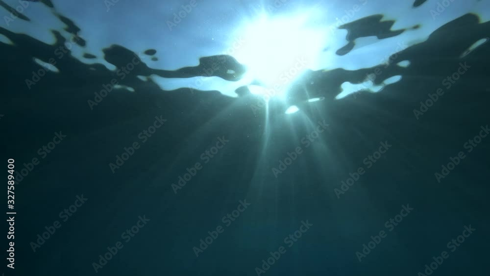 Slow motion, Sunrays penetrate through the surface of the water. Underwater light creates a beautiful veil, consisting of sunlight. Underwater ocean waves oscillate and flow with the rays of light Slow motion, Sunrays penetrate through the surface of the water. Underwater light creates a beautiful veil, consisting of sunlight. Underwater ocean waves oscillate and flow with the rays of light