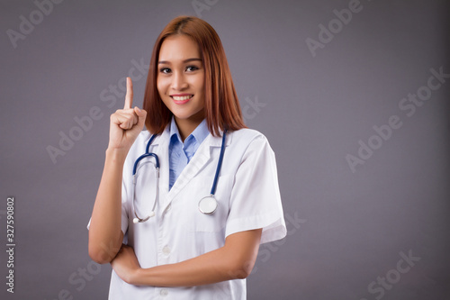 portrait of asian woman doctor isolated  confident and friendly female doctor pointing up one finger