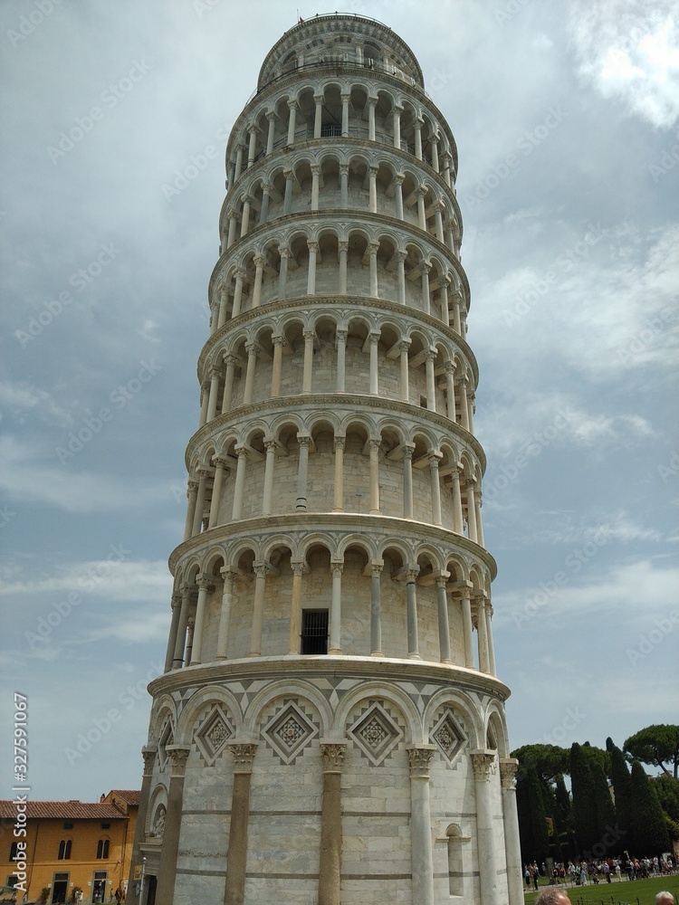 Closeup of the leaning tower of Pisa, looking up at the stone carvings from ground level