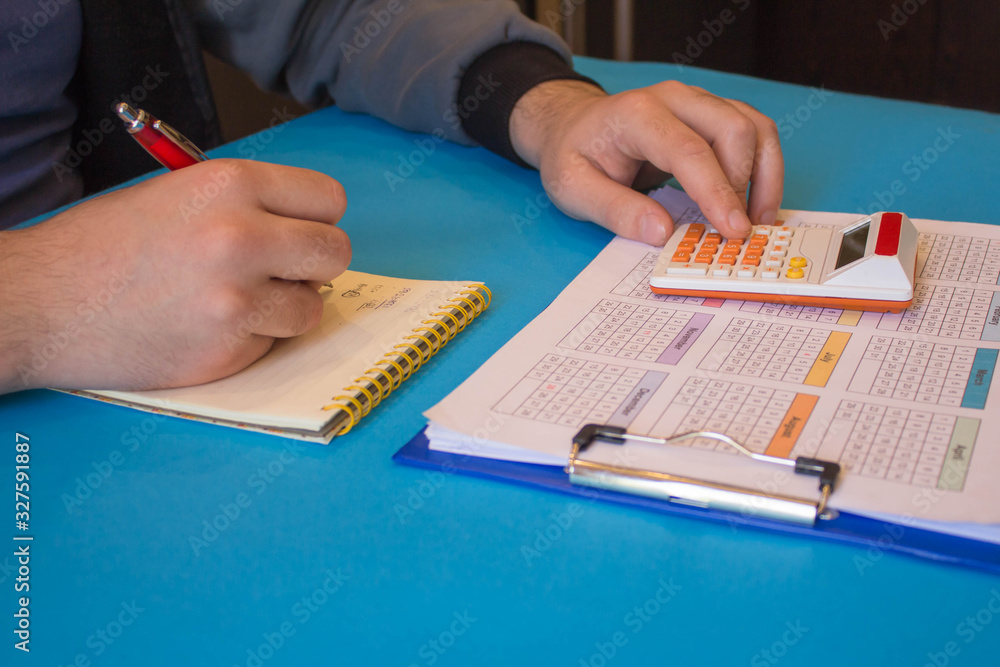 Close up view of bookkeeper or financial inspector hands making report, calculating or checking balance. Home finances, investment, economy, saving money or insurance concept Close up view of bookkeeper or financial inspector hands making report, calculating or checking balance. Home finances, investment, economy, saving money or insurance concept