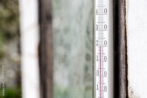 old glass thermometer for measuring outdoor temperature, showing twenty degrees centigrade, closeup