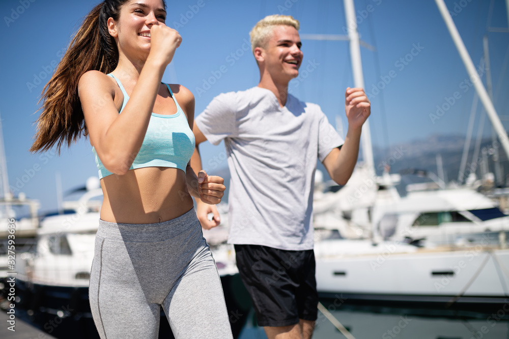 Cheerful fit couple training on the beach. Sport concept