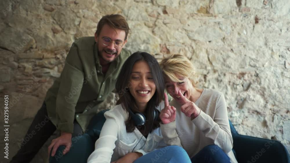 Colleagues taking a selfie, sitting on a couch at the office Colleagues taking a selfie, sitting on a couch at the office