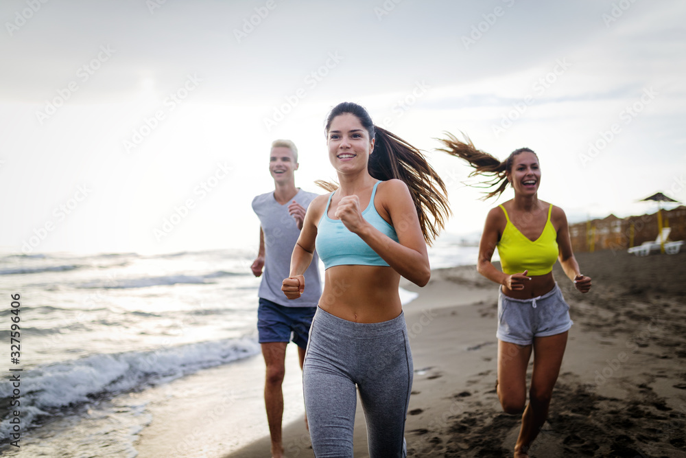Group of athletes running on ocean front. Friends in sportswear training together outdoors. Group of athletes running on ocean front. Friends in sportswear training together outdoors.