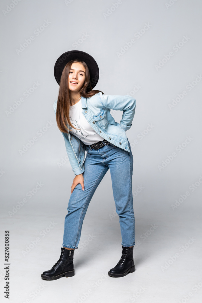 Full body portrait of an attractive young girl wearing jeans jacket and black hat with white background Full body portrait of an attractive young girl wearing jeans jacket and black hat with white background