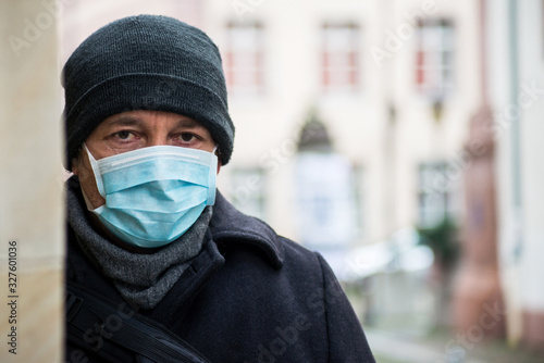 Portrait of man with medical mask to protect against the corona virus in the street