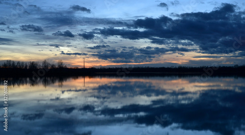 Beautiful evening landscape with reflection of clouds in a lake