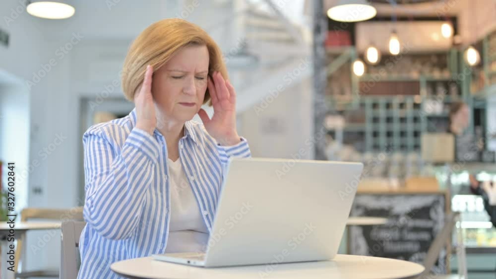 Laptop use by Creative Old Woman with Headache in Cafe Laptop use by Creative Old Woman with Headache in Cafe