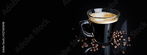 black coffee with roaseted beans on black background