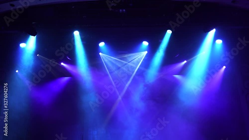 Setting up the stage light before the show. Bright multi-colored rays of spotlights, geometric patterns on a black background. ultraviolet light 4K, blue, violet colors