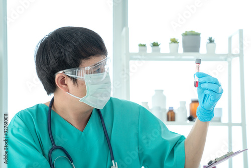 Doctor Hand holding test tube. Asian doctor holding Coronavirus (COVID-19) bloods sample tube and nCoV-19 folder in lab.