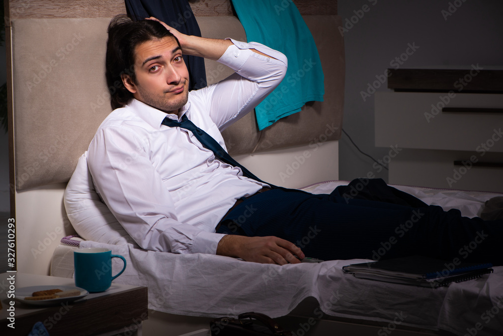 Obraz premium Young employee working at home after night shift