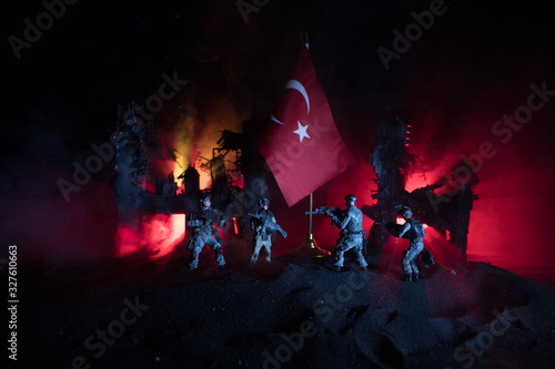 Silhouette of soldier with rifle against a turkish flag. Selective focus