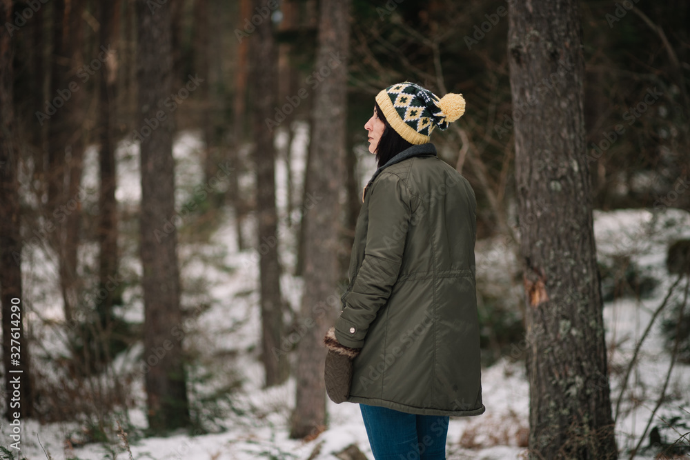 Brunette woman standing in winter snowy park Brunette woman standing in winter snowy park