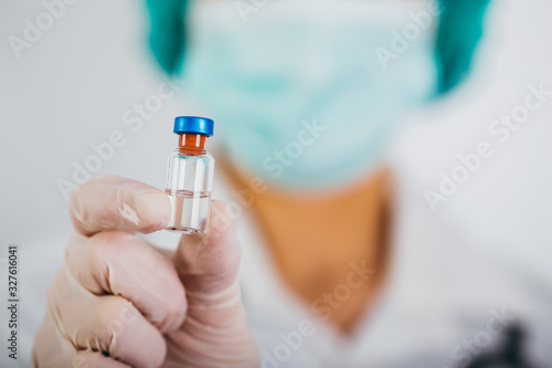 Vaccine bottle and syringe in a doctors hands close-up. COVID-19/ Coronavirus concept.