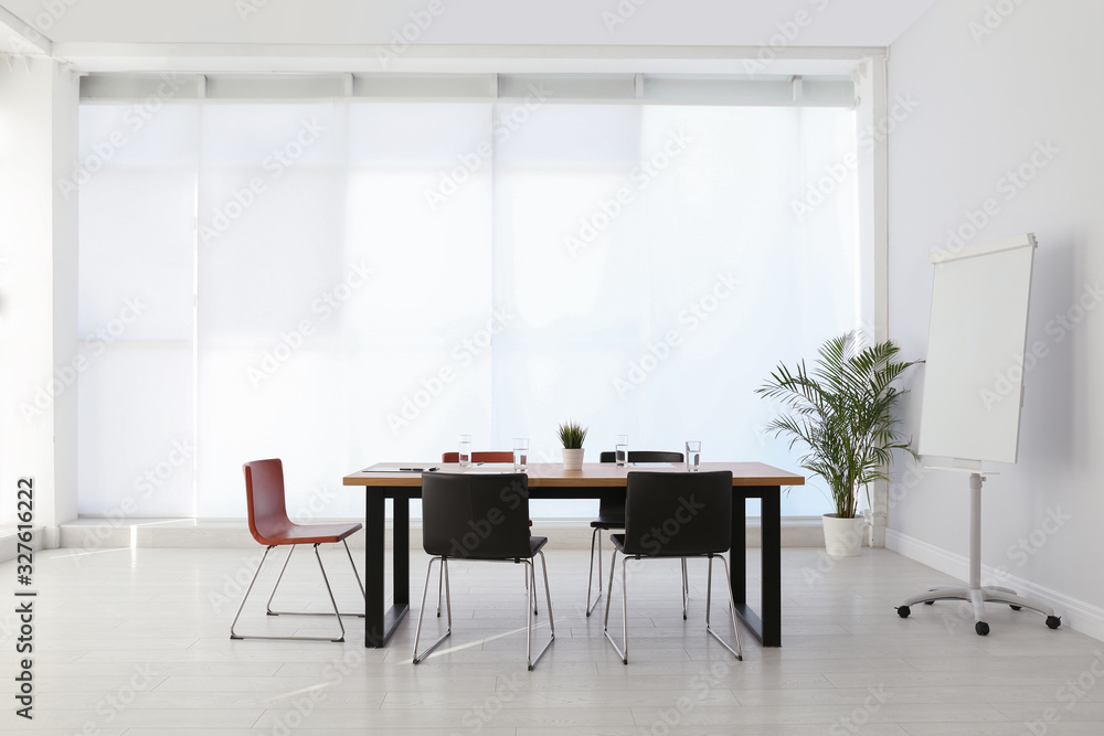 Fototapeta premium Simple office interior with large table and chairs