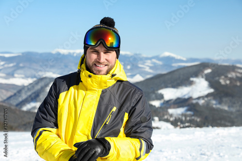 Happy young man in mountains. Winter vacation
