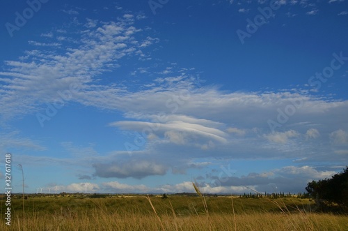 Vielfältige Wolkenformation am blauen Himmel über gelbem Feld auf Oahu, Hawaii