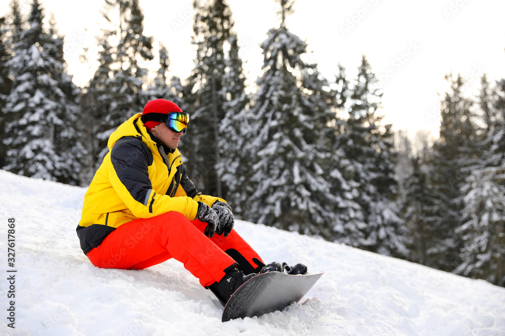 Male snowboarder on snowy hill. Winter vacation