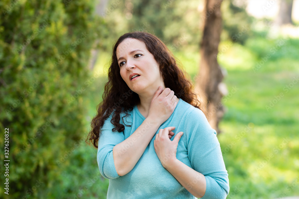 Woman suffering itching scratching neck because it hurts as a result of allergy Woman suffering itching scratching neck because it hurts as a result of allergy