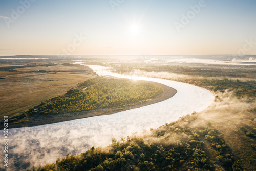 Aerial view of river bend in countryside at sunrise. Nature landscape with Chulym River near Achinsk in Krasnoyarsk Krai, Siberia, Russia
