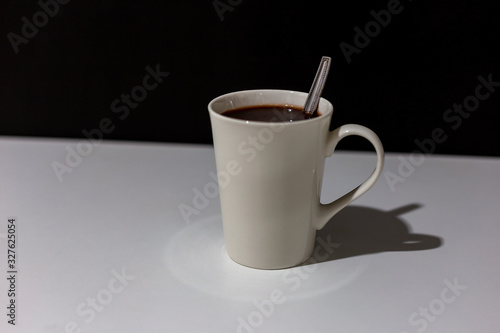 Coffee in a white cup on the table and dark background