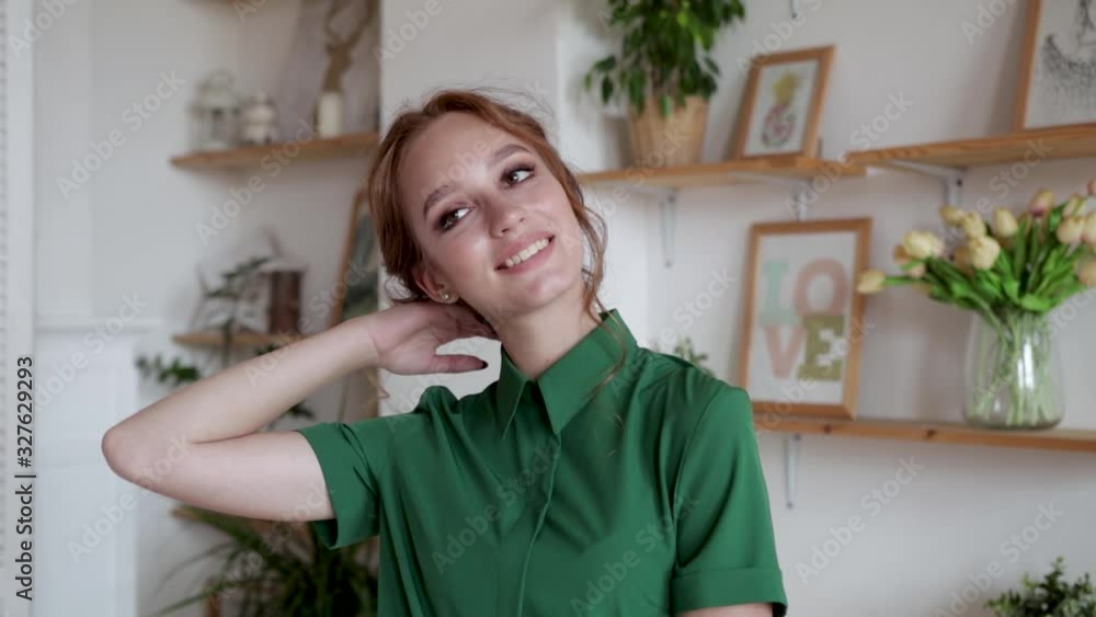 Young girl in a green blouse with red hair smiling in a beautiful interior posing, slow motion Young girl in a green blouse with red hair smiling in a beautiful interior posing, slow motion