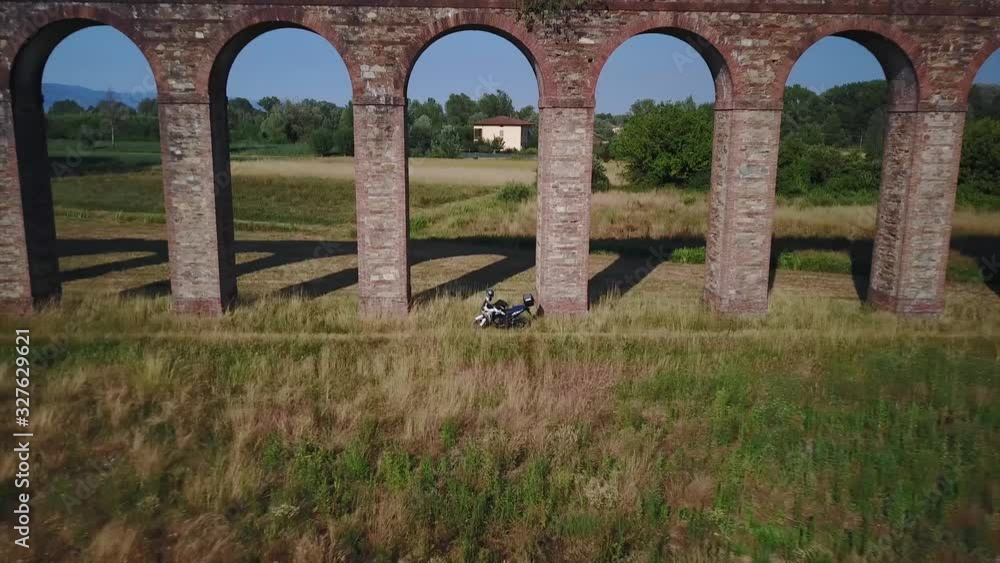 Aerial motorbike trail parked near nottolini aqueduct In lucca italy sunny day Aerial motorbike trail parked near nottolini aqueduct In lucca italy sunny day