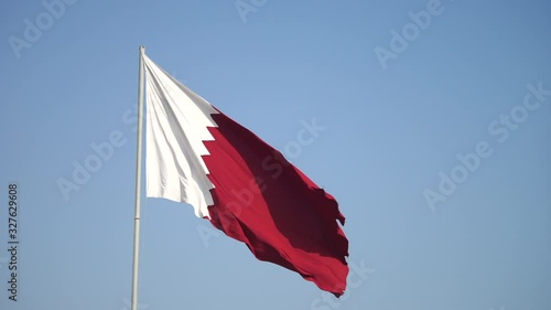 Elegant Qatar flag flying in the sky on a bright sunny day in slow motion