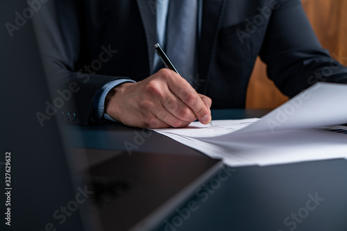 A man broker signing the mortgage contract at the real property agent office. The concept of entering into legal power to take liabilities.