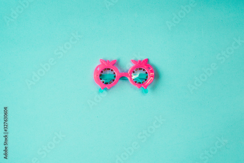 Pink toy glasses on an aquamarine blue background